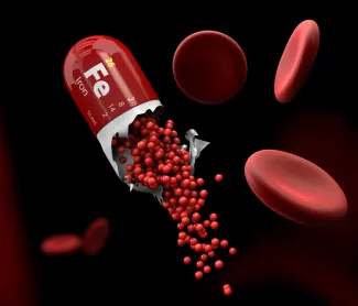 Iron supplement capsule releasing iron with red blood cells — iron deficiency anemia treatment illustration